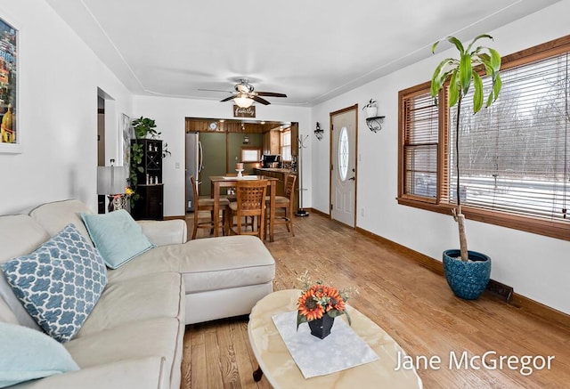 living room with ceiling fan and light hardwood / wood-style flooring