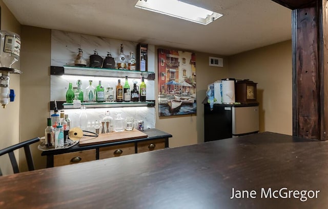 bar featuring stainless steel refrigerator