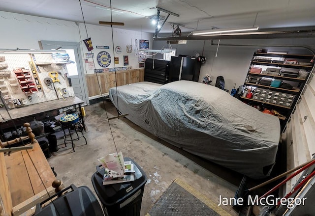 bedroom featuring a workshop area, concrete floors, and wooden walls