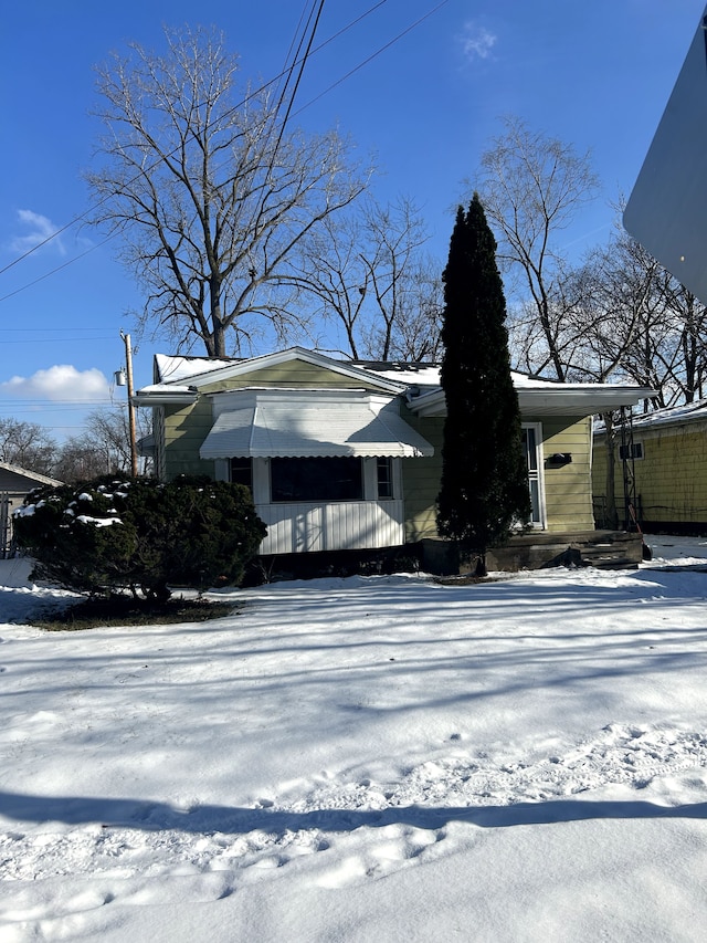 view of snowy exterior featuring covered porch