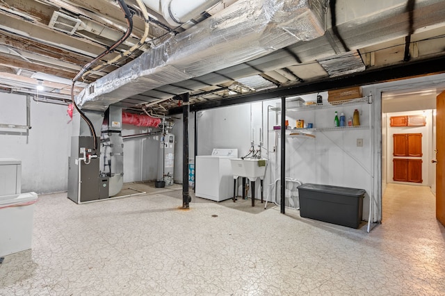 basement with washer / dryer, sink, heating unit, and gas water heater