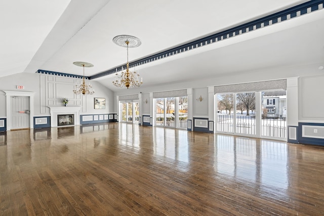 unfurnished living room featuring wood-type flooring, lofted ceiling, and a notable chandelier