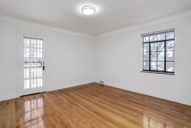 spare room featuring hardwood / wood-style floors and ornamental molding