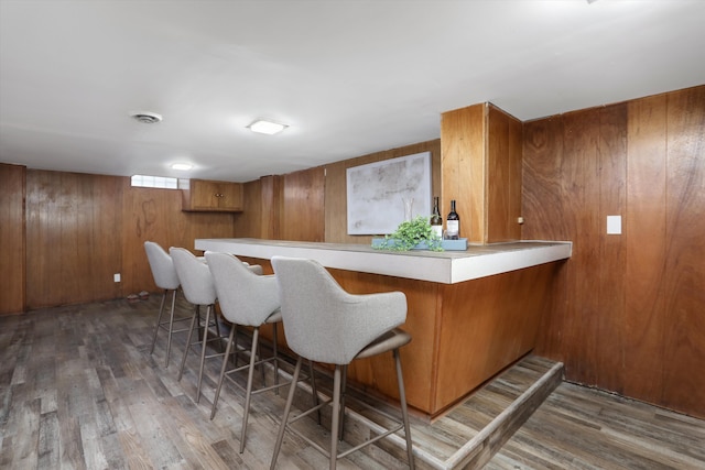 bar with dark wood-type flooring and wooden walls