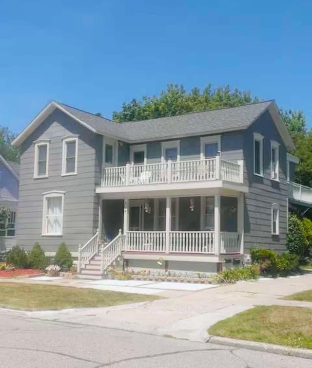 view of front of property with covered porch and a balcony