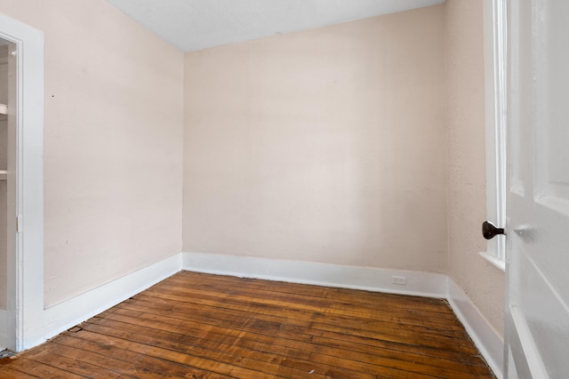 unfurnished room with dark hardwood / wood-style flooring