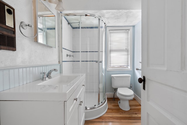 bathroom with a shower with door, vanity, hardwood / wood-style flooring, and toilet