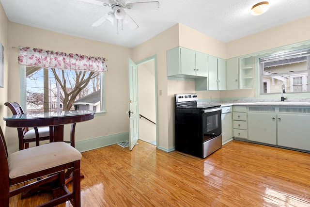 kitchen featuring sink, light hardwood / wood-style flooring, ceiling fan, a textured ceiling, and stainless steel electric range oven