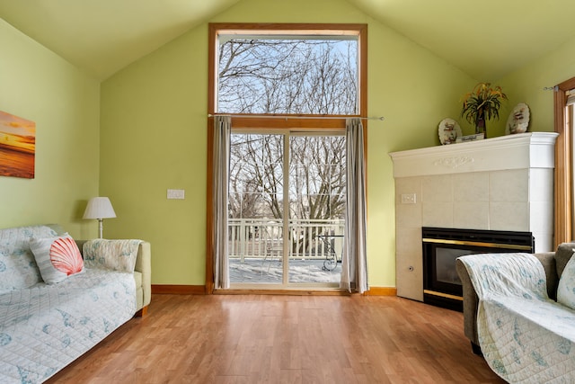 living room featuring a wealth of natural light, light hardwood / wood-style floors, and a tile fireplace