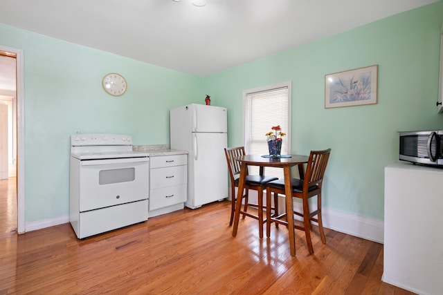 kitchen with white appliances and light hardwood / wood-style floors