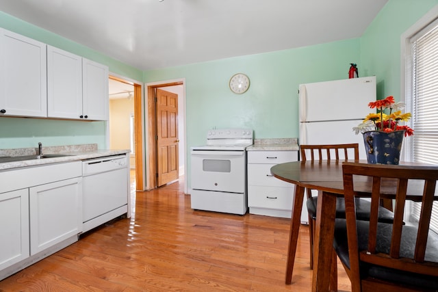 kitchen with sink, white appliances, light hardwood / wood-style flooring, and white cabinets