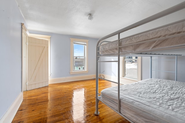 bedroom with hardwood / wood-style flooring and a textured ceiling