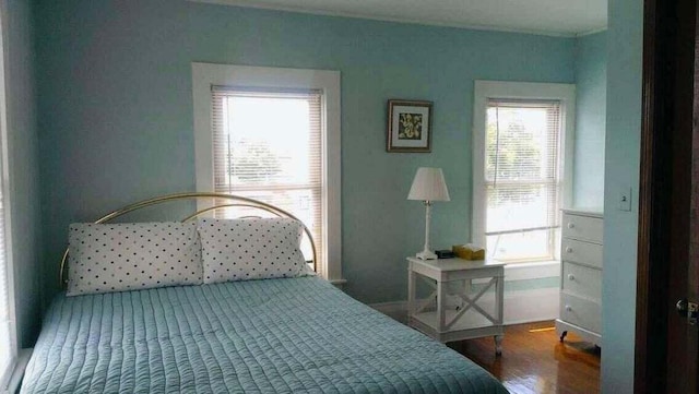 bedroom with wood-type flooring and multiple windows