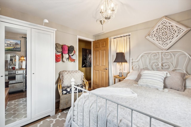 bedroom featuring wood-type flooring and a notable chandelier