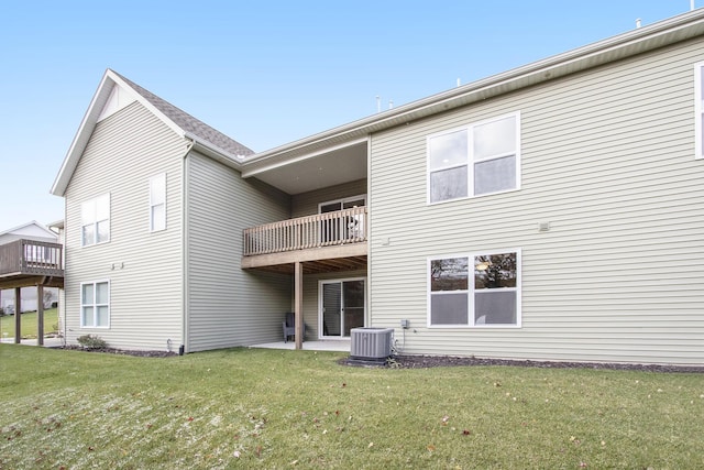 rear view of house with a lawn and central AC unit