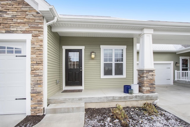 doorway to property with covered porch and a garage