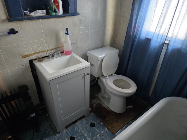 bathroom featuring toilet, tile walls, tile patterned floors, and vanity