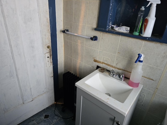 bathroom with tasteful backsplash, vanity, and radiator heating unit