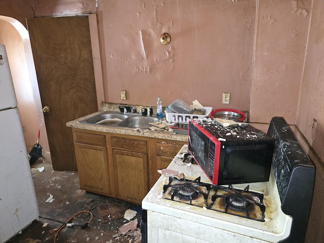 kitchen featuring white refrigerator and sink