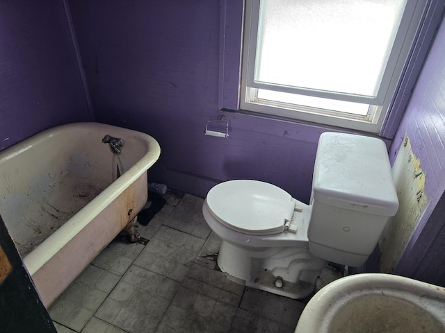 bathroom featuring a tub to relax in and toilet