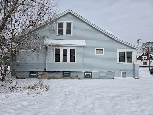 view of snow covered rear of property