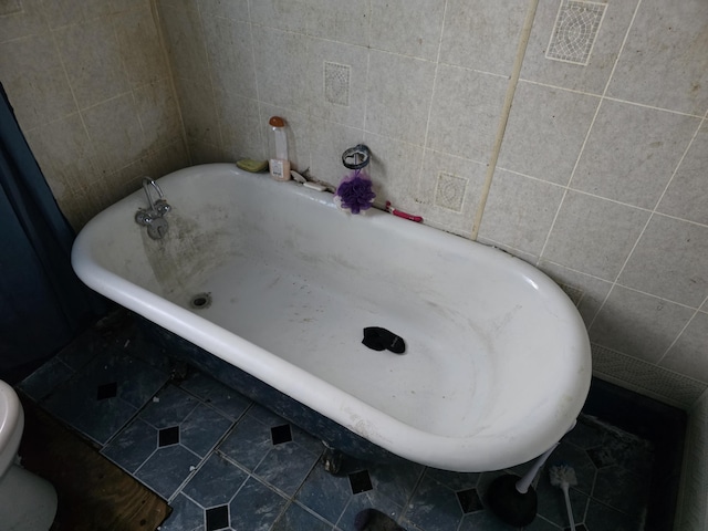 bathroom with tile walls and a bathing tub