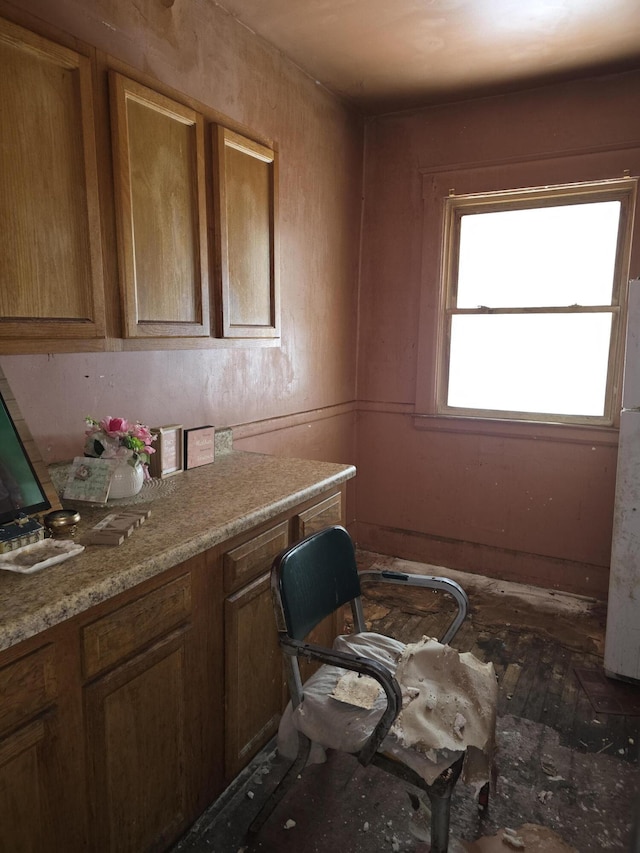 kitchen featuring light stone counters and white refrigerator