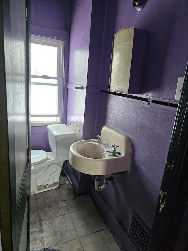 bathroom with sink, tile walls, and toilet