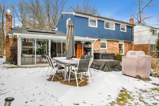 snow covered house featuring solar panels