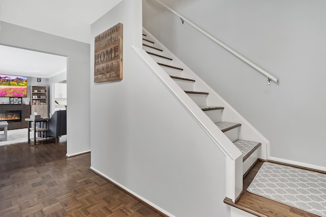 stairway featuring parquet floors