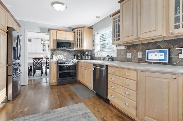 kitchen featuring stainless steel appliances, light brown cabinets, dark hardwood / wood-style flooring, and decorative light fixtures