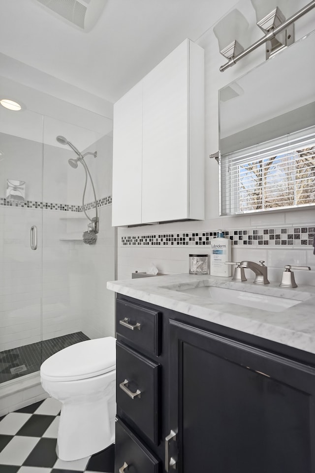 bathroom featuring an enclosed shower, vanity, decorative backsplash, and toilet