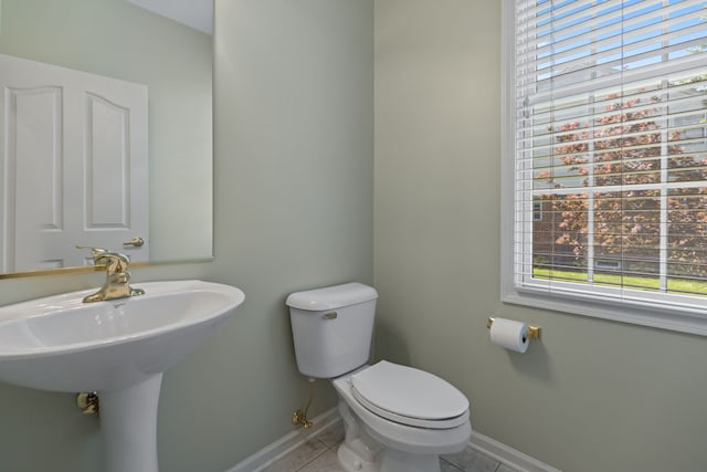 bathroom with toilet, tile patterned flooring, and plenty of natural light