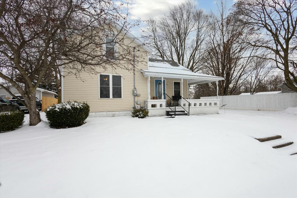 view of snow covered back of property