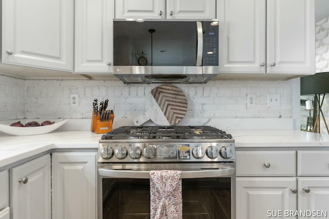 kitchen featuring backsplash, white cabinets, and stainless steel appliances