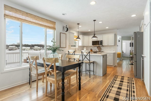 dining space with light hardwood / wood-style floors and sink