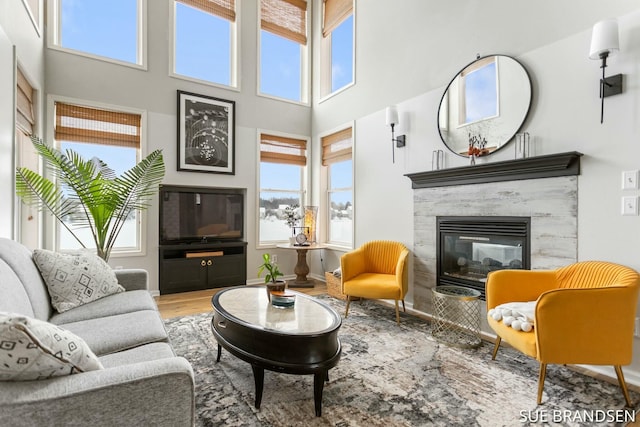 living room featuring a towering ceiling, a wealth of natural light, and hardwood / wood-style floors