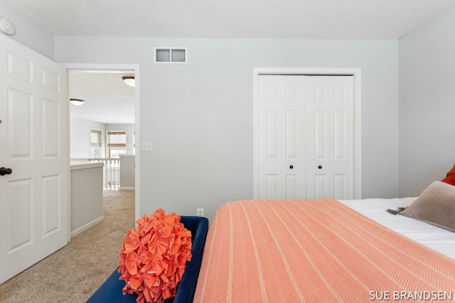 carpeted bedroom with a textured ceiling and a closet