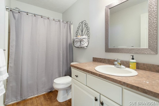 bathroom with hardwood / wood-style flooring, toilet, and vanity