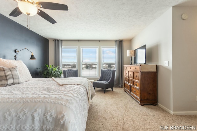 bedroom with ceiling fan, light carpet, and a textured ceiling