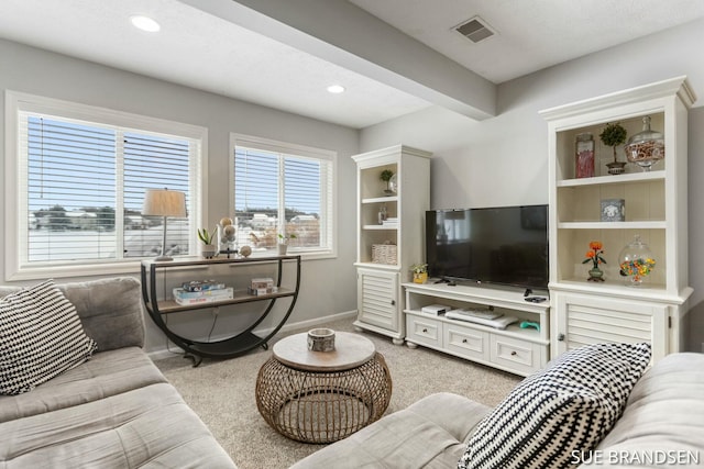 carpeted living room with beam ceiling