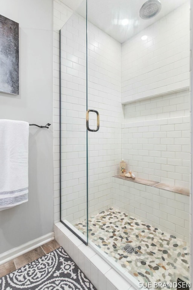 bathroom featuring hardwood / wood-style floors and a shower with door