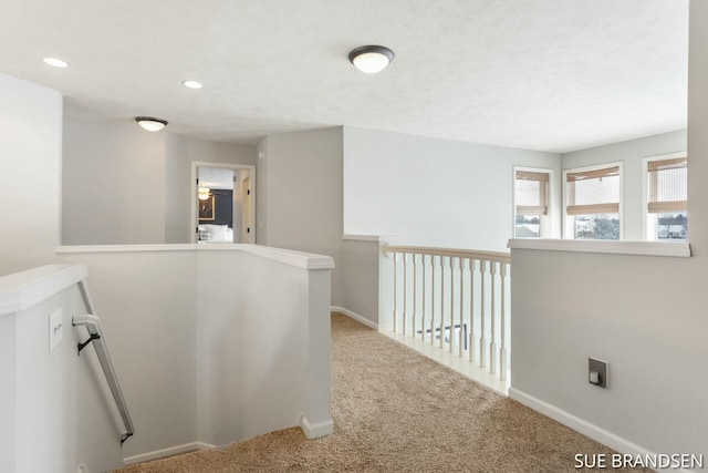 hallway featuring a textured ceiling and carpet flooring