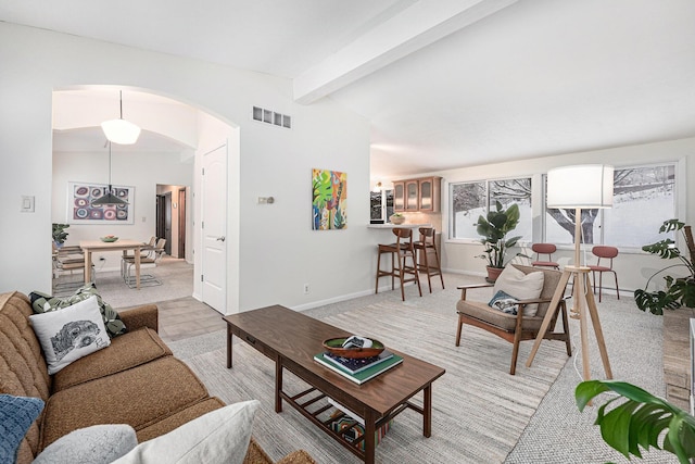 living room with light colored carpet, lofted ceiling with beams, and a healthy amount of sunlight