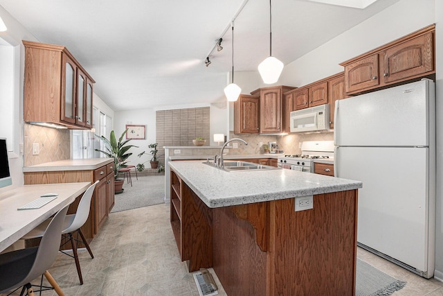 kitchen featuring kitchen peninsula, sink, backsplash, and white appliances