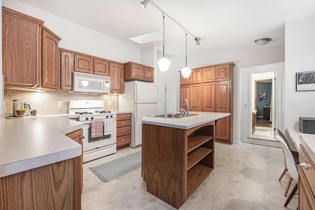 kitchen featuring pendant lighting, decorative backsplash, sink, white appliances, and track lighting