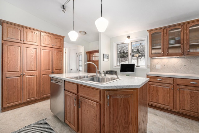 kitchen with decorative light fixtures, backsplash, a center island with sink, stainless steel dishwasher, and sink