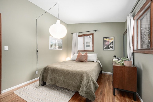 bedroom with hardwood / wood-style floors and vaulted ceiling