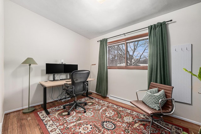 office area featuring lofted ceiling, wood-type flooring, and a baseboard radiator