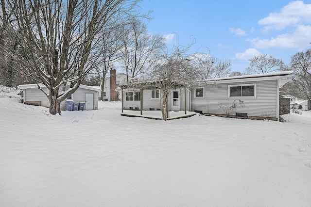 snow covered property featuring a storage shed